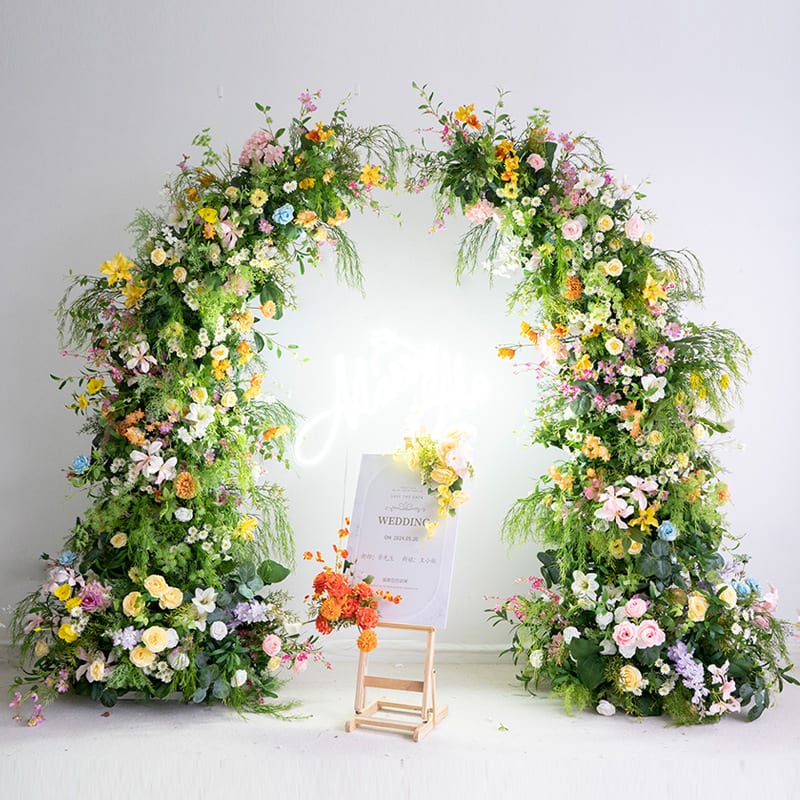 Bright artificial flower arch with colorful faux florals for wedding and event decor